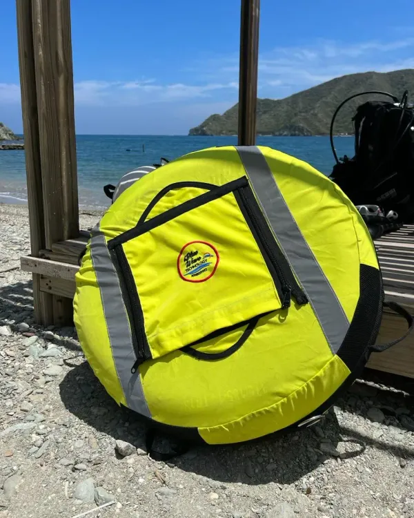 Boya de buceo amarilla con reflectivos sobre la playa